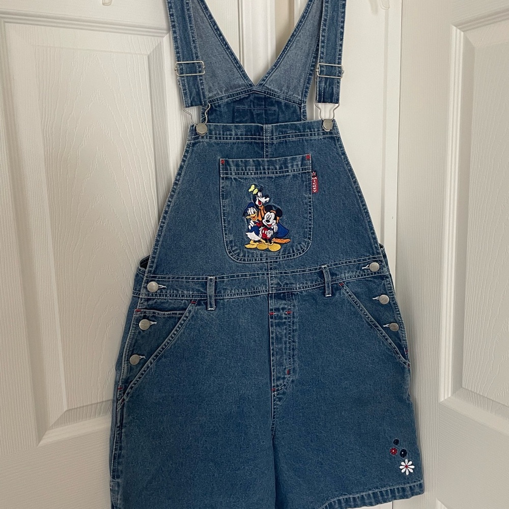 Mickey Unlimited Denim Shorts Overalls. The front pocket is embroidered.